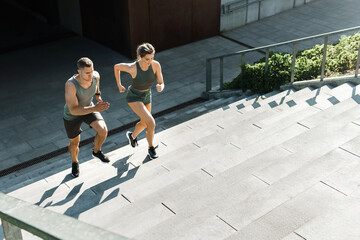 Sportive couple during workout stair running outdoors