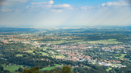 Panoramic view of the Po Valley in the province of Biella and Vercelli. Natural and city panorama on a sunny summer day in northern Italy. City, crops and rice fields in the background. Landscape.
