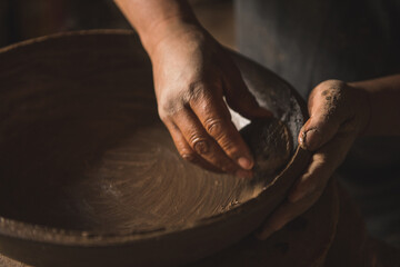 Manufacturer of handmade clay pots working in his workshop to create traditional Mexican kitchen...