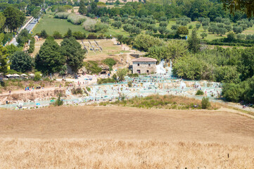 The gorgeous natural thermal bath of Saturnia. Warm water spills out of the rock creating a waterfall with spontaneous ponds, the "Cascate del Molino" in Tuscany, Italy