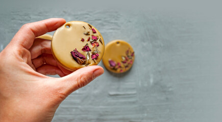 Aroma sachet from beeswax in a woman's hand. Rose scent. Florentine sachet. Banner with place for...