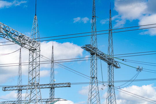 View of huge electric supply. Big electricity construction at the blue cloudy sky background. Low angle view. Stock photo