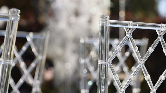 Transparent plastic Chiavori chairs for guests on the street close-up. Autumn wedding ceremony on the street on the green lawn.