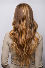 Young woman showing her beautiful hair after dyeing and styling