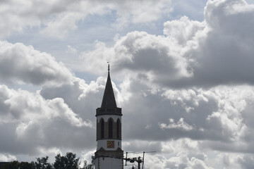 kirchturm vor bewölktem himmel