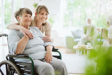 Happy senior woman and helpful caregiver, nursing home concept photos - 460371394