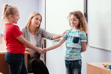 Two children shake hands in agreement during class