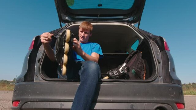 Tie roller skates man on the car trunk