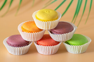 multicolored macaroons in white packaging are stacked in a pyramid