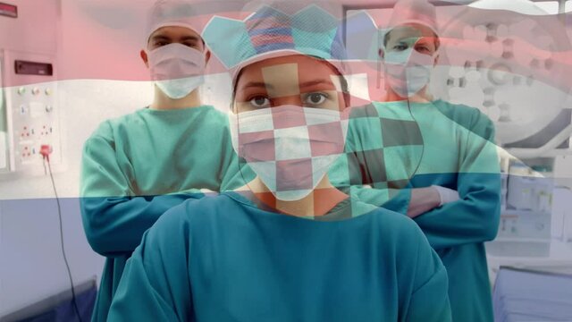 Animation of flag of croatia waving over surgeons in operating theatre