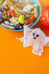 ghost  candy bowl of cookies, candy, chocolates and sweets, Halloween Jack o Lantern - Trick or Treat Halloween card orange background