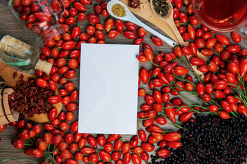 Dog rose, bunch branch Rosehips, types Rosa canina hips, essential oil and hot herbal tea cup on...