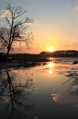Obraz premium half frozen lake at sunset in winter