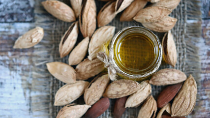 Almond oil in a jar. Almonds in shells.