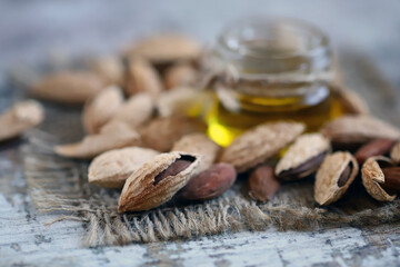 Almond oil in a jar. Almonds in shells.