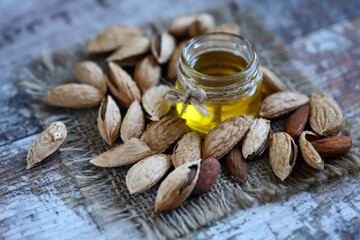 Almond oil in a jar. Almonds in shells.