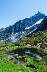Naklejka na ściany i meble Mountain lake between Swiss Alps