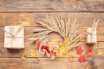Dried floral wreath, autumn rustic wreath with dry grass, wildflowers  on rustic wooden table. Floral autumn door wreath from natural materials. Fall flower decoration workshop. Top view