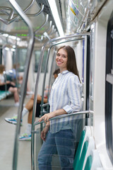 Cheerful young girl inside metro carriage student return home after successful exam in university....