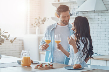 Obraz na płótnie Canvas Beautiful young couple enjoying breakfast together while spendin