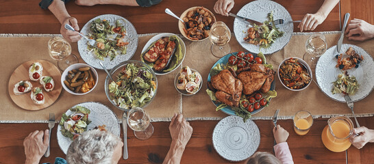 Top view of multi-generation family communicating and smiling while having dinner together