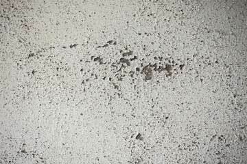 White damp wall showing paint cracking open and breaking or peeling off. The fragile white lining of the walls. Abstract cracked and swollen black-white background. Macro close-up view. 