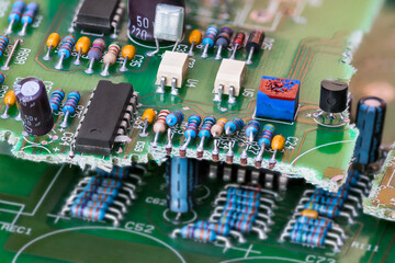Closeup of electronic waste of broken green printed circuit board with through-hole components...