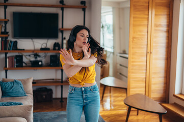 Young attractive woman dancing and listening music on a headphones