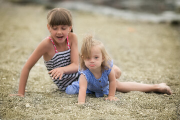 Fototapeta premium sister lovingly embraces his sister with Down syndrome