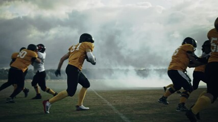 American Football Field Two Teams Play: Successful Player Jumping Over Defense Running to Score Touchdown Points. Professional Athletes Compete for the Ball, Fight for Victory. Dramatic Slow Motion - Powered by Adobe