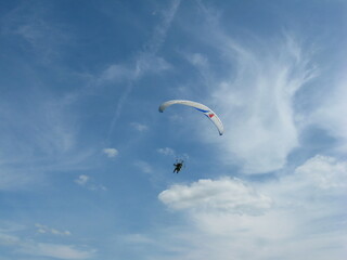 Paraglider in the sky against the background of the river and sky. Summer