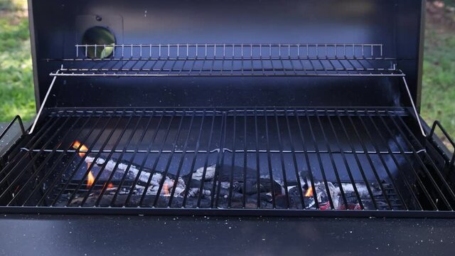 Empty barbecue grilling in summer party with flaming charcoal by open fire, a device for cook food as mea, seafood, chicken