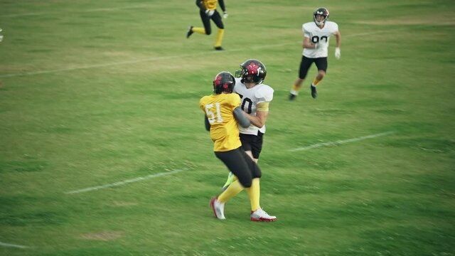 American Football Teams Start Game: Professional Players, Aggressive Face-off, Tackle, Pass, Fight for Ball and Score. Warrior Competition Full of Brutal Energy, Power, Skill. Fast Paced Wide Shot - Powered by Adobe