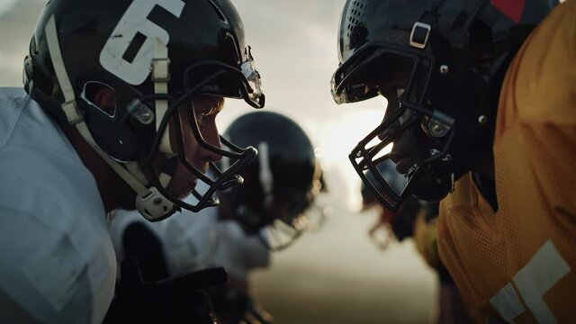 American Football Game Start Teams Ready: Close-up Portrait of Two Professional Players, Aggressive Face-off. Competitive Warriors Full of Brutal Energy, Power, Skill. Dramatic Stare. Cinematic Shot