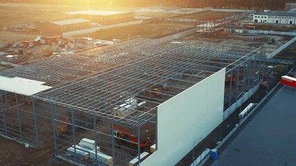 Aerial of a warehouse under construction (in a course of building) in a logistics park - Powered by Adobe