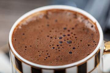 Turkish Coffee on wood table. Turkish Coffee ceramic traditional cup, coffee beans scattered on table.