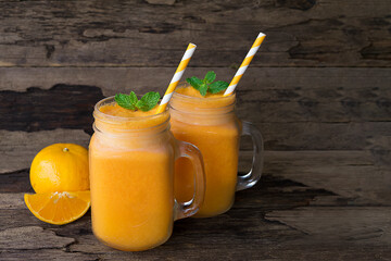 Orange juice fruit smoothies yogurt drink yellow healthy delicious taste in a glass slush for weight loss on wooden background.