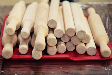 A large number of rolling pins for rolling out the dough are on the tray