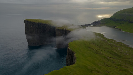 Beautiful aerial view of the Bøsdalafossur waterfall and Trælanípan magnificent landmarks in the Faroe Islands