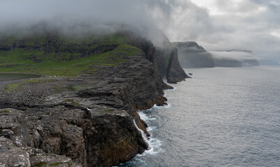 Beautiful aerial view of the Bøsdalafossur waterfall and Trælanípan magnificent landmarks in the Faroe Islands