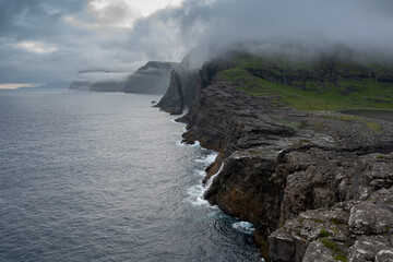 Beautiful aerial view of the Bøsdalafossur waterfall and Trælanípan magnificent landmarks in the Faroe Islands