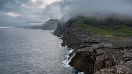 Beautiful aerial view of the Bøsdalafossur waterfall and Trælanípan magnificent landmarks in the Faroe Islands
