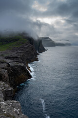 Beautiful aerial view of the Bøsdalafossur waterfall and Trælanípan magnificent landmarks in the Faroe Islands