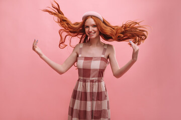 Young fair-skinned girl tosses her long red hair to sides with copy space. Slim teenager is dressed...