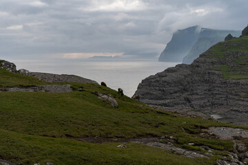 Beautiful aerial view of the Bøsdalafossur waterfall and Trælanípan magnificent landmarks in the Faroe Islands