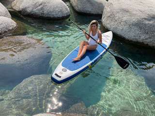 Beautiful yang lady relaxes on the paddle board 