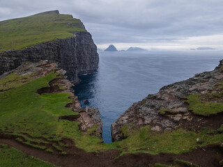 Beautiful aerial view of the B&oslash;sdalafossur waterfall and Tr&aelig;lan&iacute;pan magnificent landmarks in the Faroe Islands