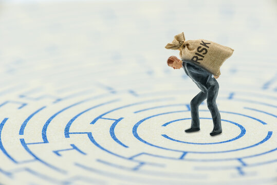 Risk assessment, financial concept, Leader bears or carry a risk bag on his back, finds a way to escape from a maze, depicting responsible or accept the risk that his company or business has involved.