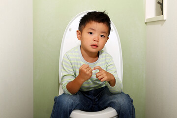 日本の水洗トイレに座っている男の子。