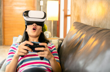 Young asian woman is using virtual reality headset.Concept of virtual reality, simulation, gaming and future technology.Asian woman play game in living room apartment.